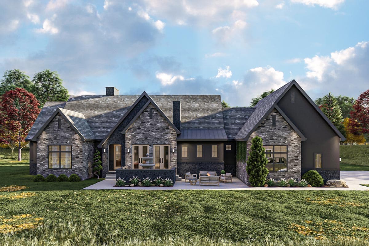 House plan exterior with stone facade, prominent gables, multiple rooflines, and rear patio.