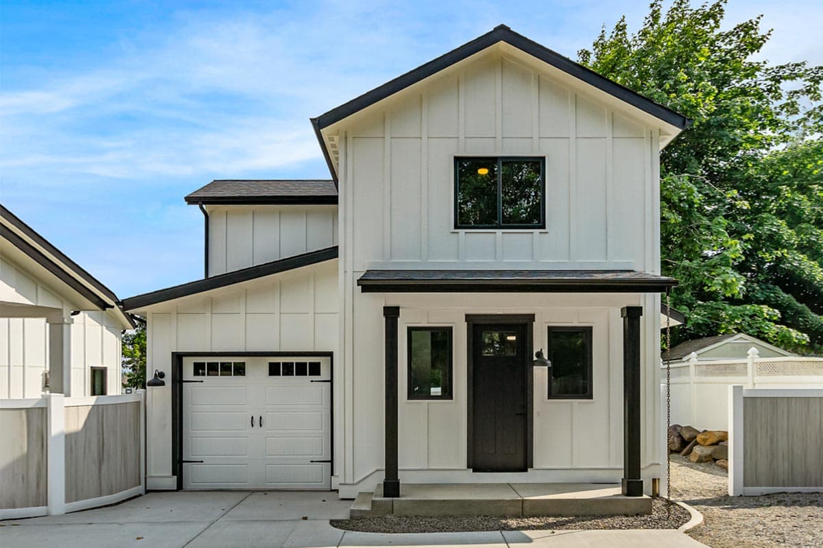 House plan exterior featuring Modern Farmhouse style with two stories, a front porch, and a gable roof with contrasting black trim.