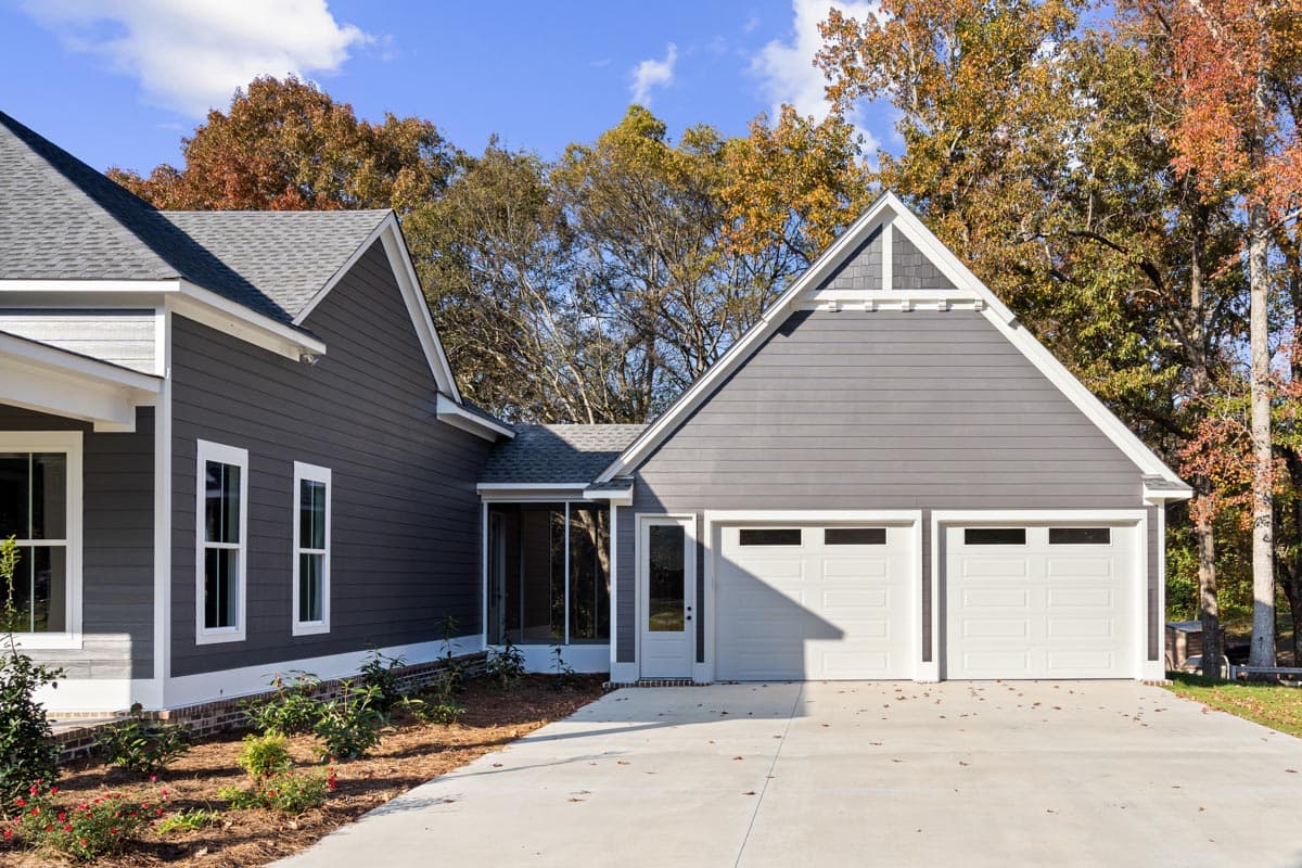 House plan exterior: Modern Farmhouse style, two stories, with a side-entry three-car garage, gabled dormers, and a screened porch.
