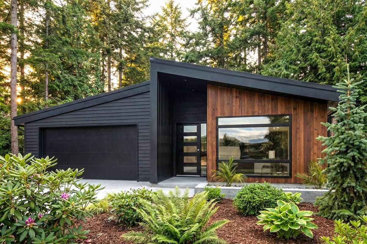 House plan exterior. Modern style with one story, flat roof, and wood siding accent. Features include a single garage and large windows.