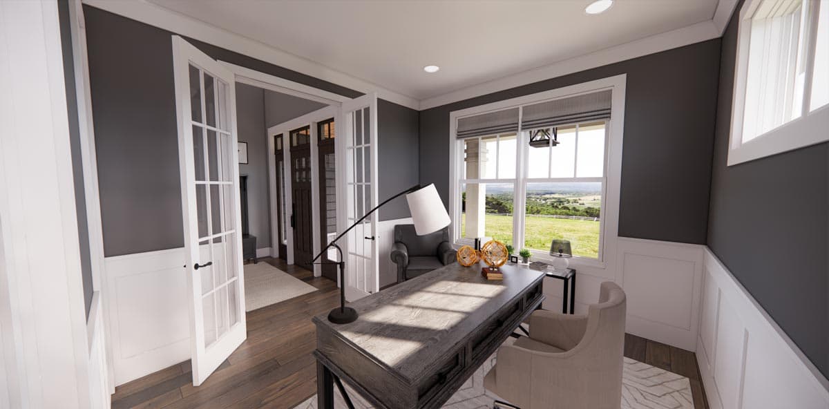 Study with French doors, desk, chair, and large windows overlooking a rural landscape.