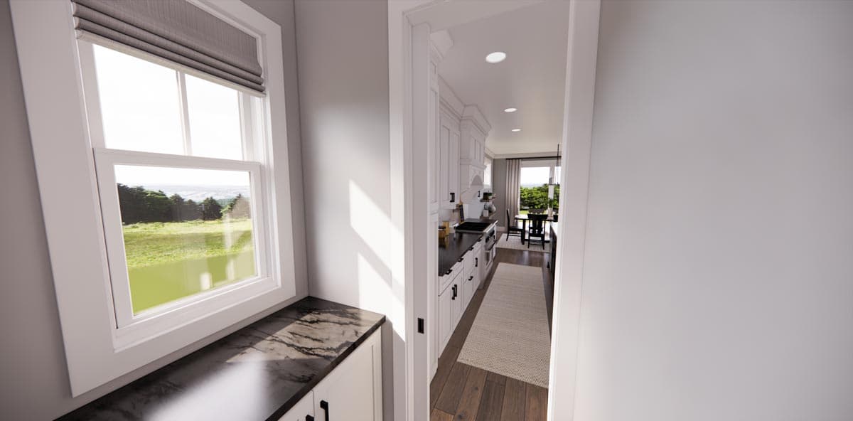 Kitchen view showing white cabinets, dark countertops, stainless steel appliances, and a dining area with large windows.
