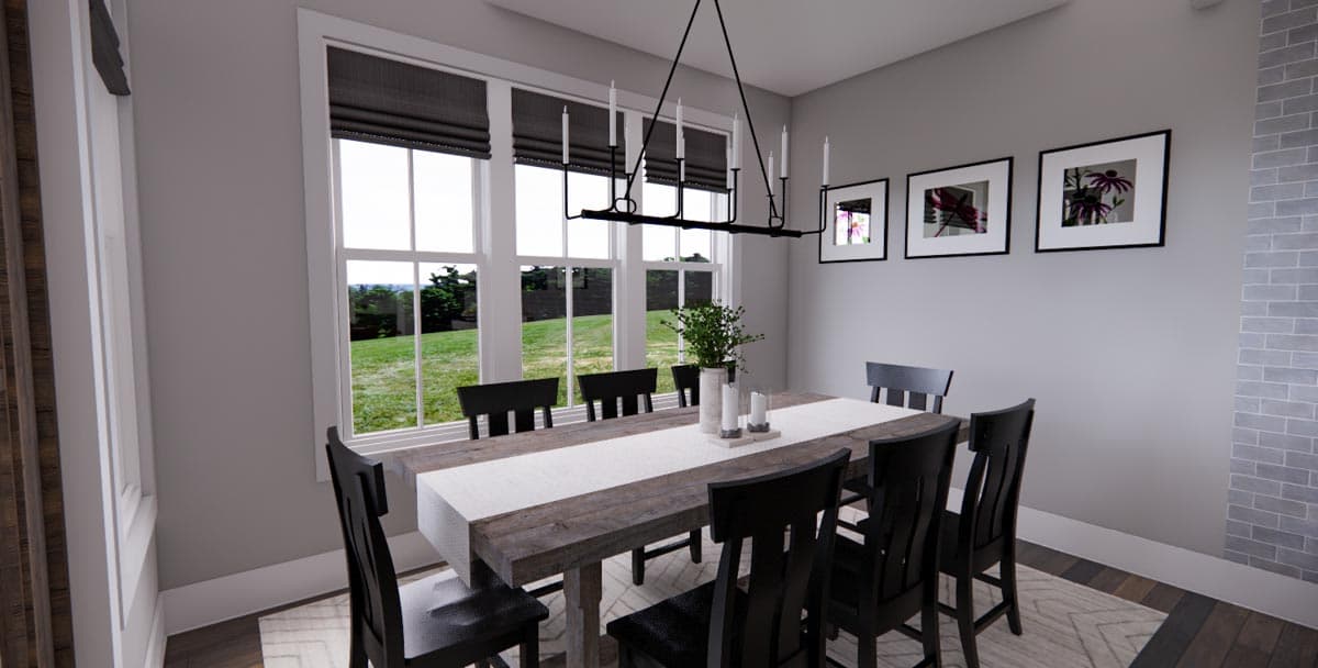 Dining room with a long wooden table set for six, large windows, and a modern chandelier. A brick accent wall is visible on the right.