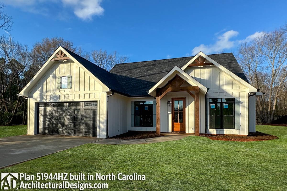 House plan exterior. Modern Farmhouse style with board and batten siding, gabled roof, and exposed wood beams on entrance.