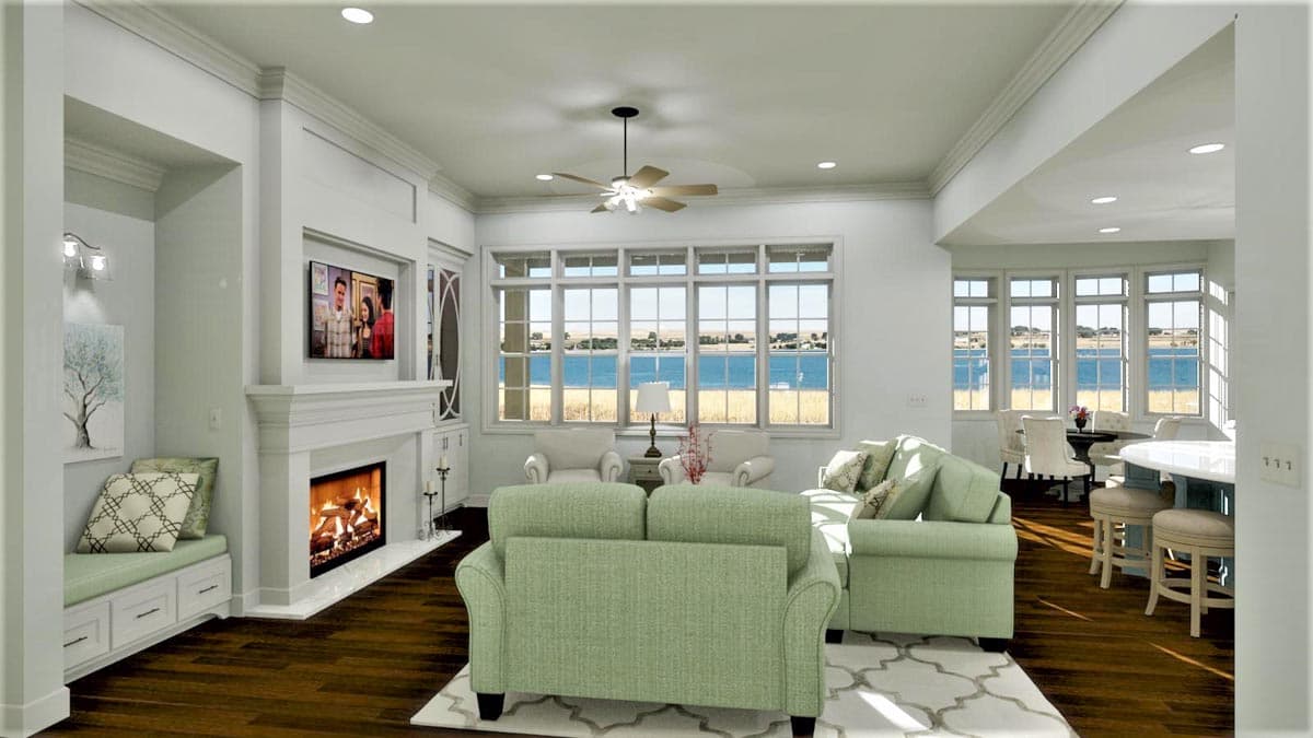 Living room with fireplace, built-in window seat, and large windows overlooking water. Features open layout to dining area and kitchen island.