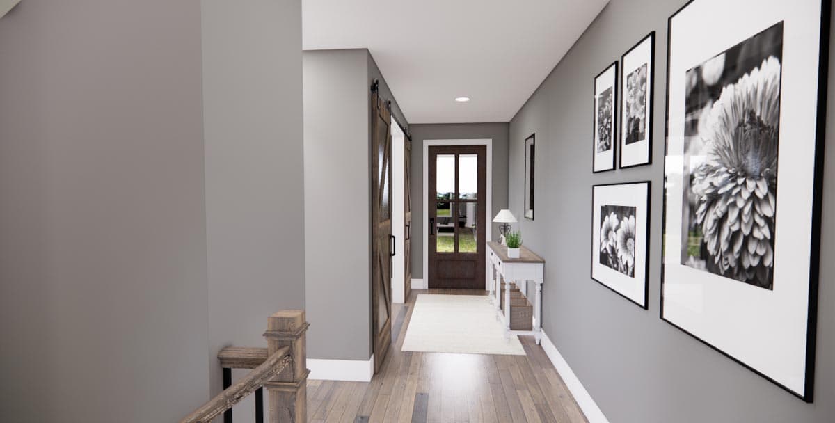 Interior hallway with barn doors, a console table, and framed floral artwork on gray walls.