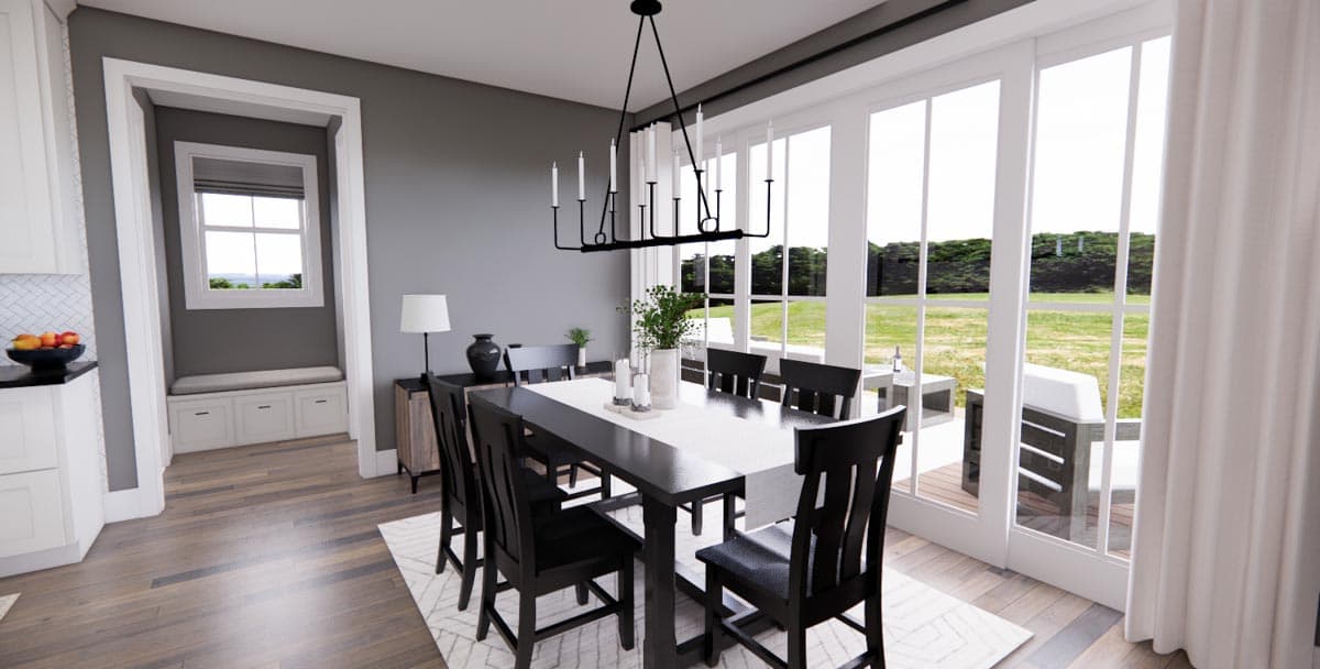 Dining room with dark wood table, chairs, chandelier, and large windows overlooking an outdoor patio.