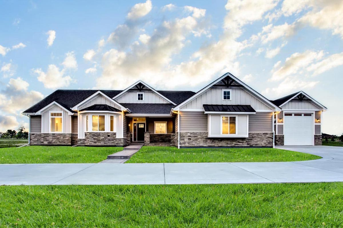 House plan exterior. Ranch style with a single story, multiple gables, stone facade accents, and attached garage. Includes a covered front entry.