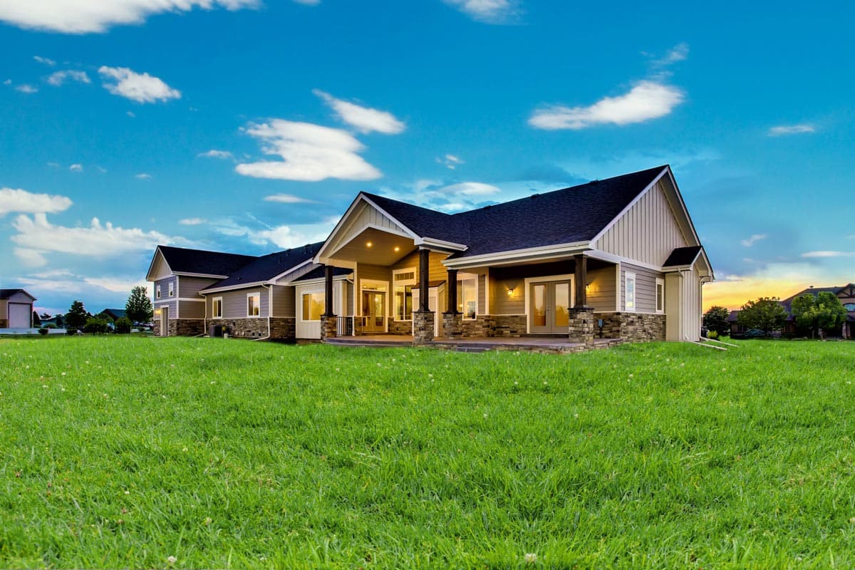 House plan exterior: Ranch style, single story with covered porch, stone accents, and multiple gables.