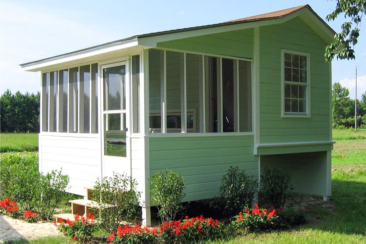 House plan exterior with green siding and white trim. Features include a screened porch, single-hung window, and a gabled roof.