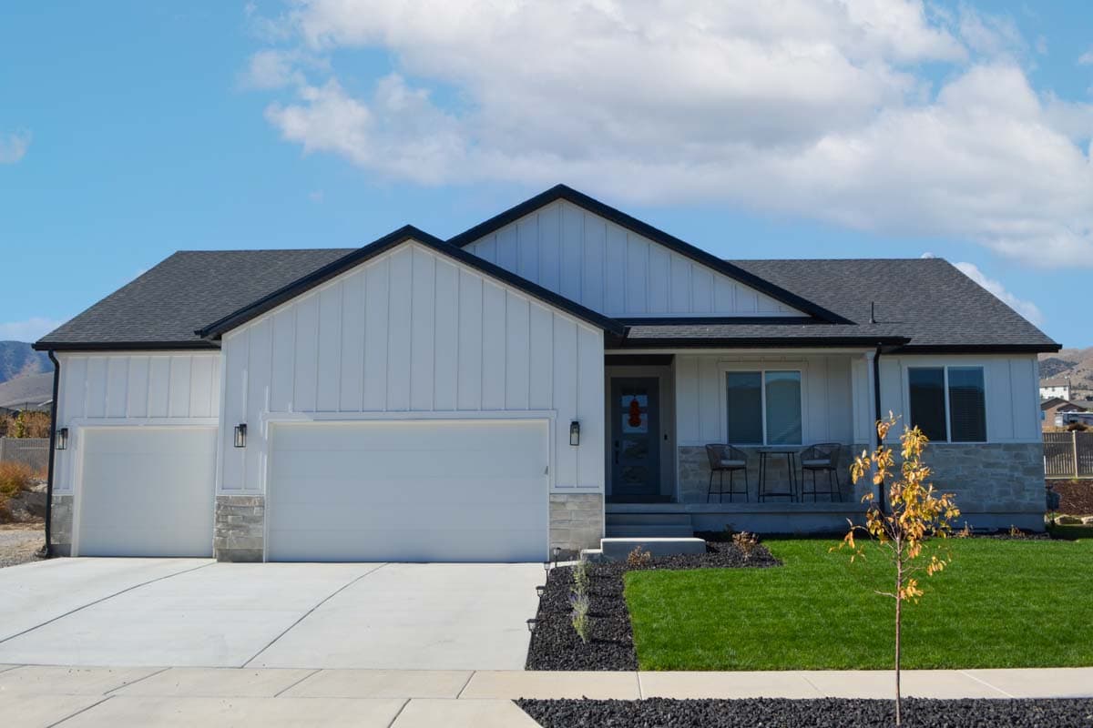 House plan exterior: Modern Farmhouse style, one-story, with a three-car garage, board and batten siding, and stone accents.