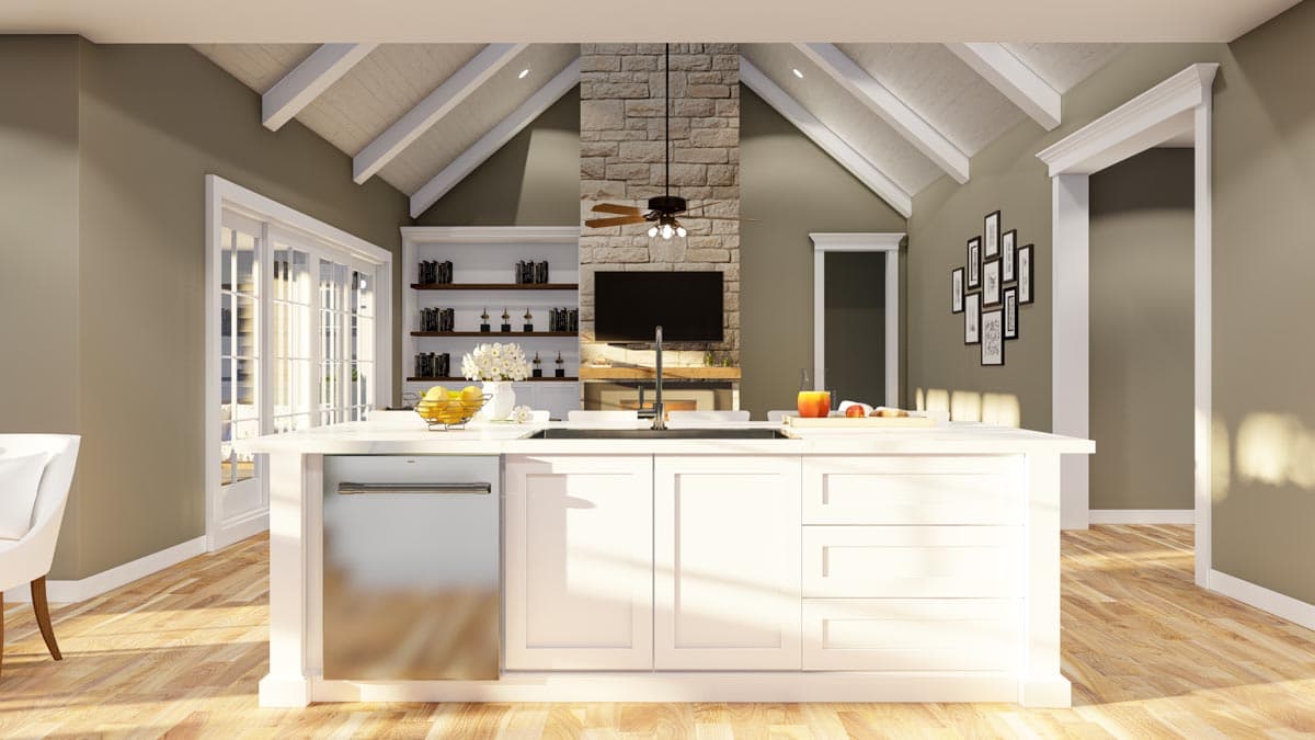 Open concept kitchen with vaulted beamed ceiling, stone fireplace, large island with sink, and French doors.