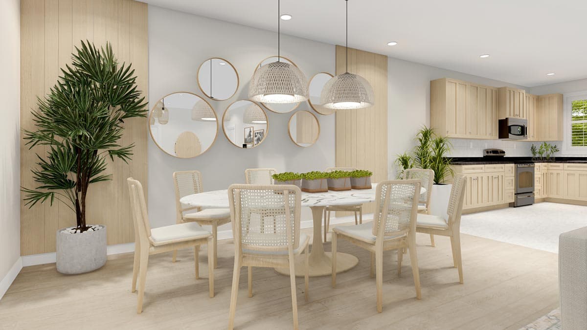 Open-concept dining area with oval marble-top table, cane-back chairs, and adjacent kitchen with light wood cabinetry and stainless steel appliances.
