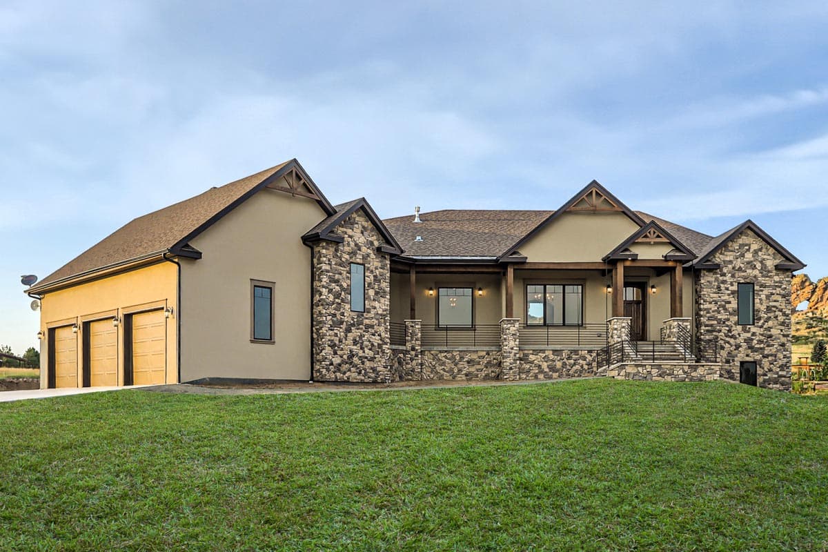 House plan exterior featuring a stucco finish, stone accents, multiple gables, a covered porch with wood beams, and a three-car garage.