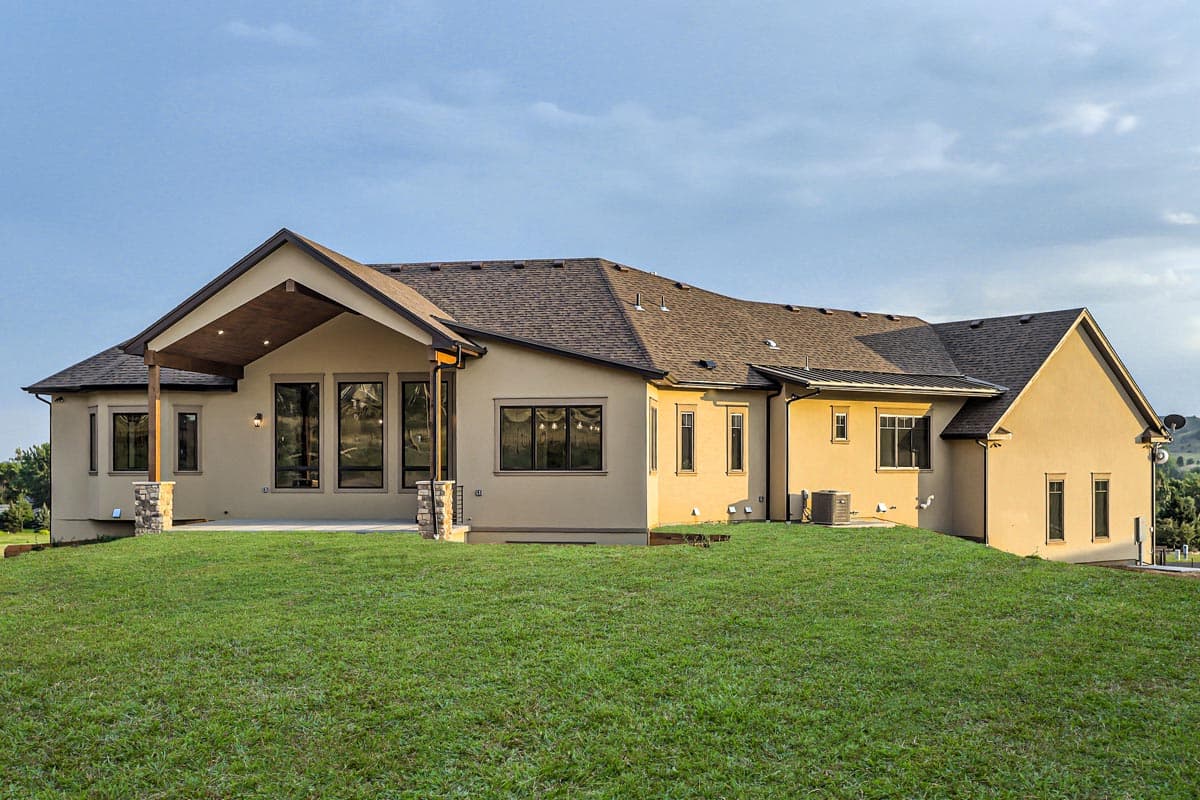 House plan exterior: Modern style, single-story, with covered patio, large windows, and stucco finish.