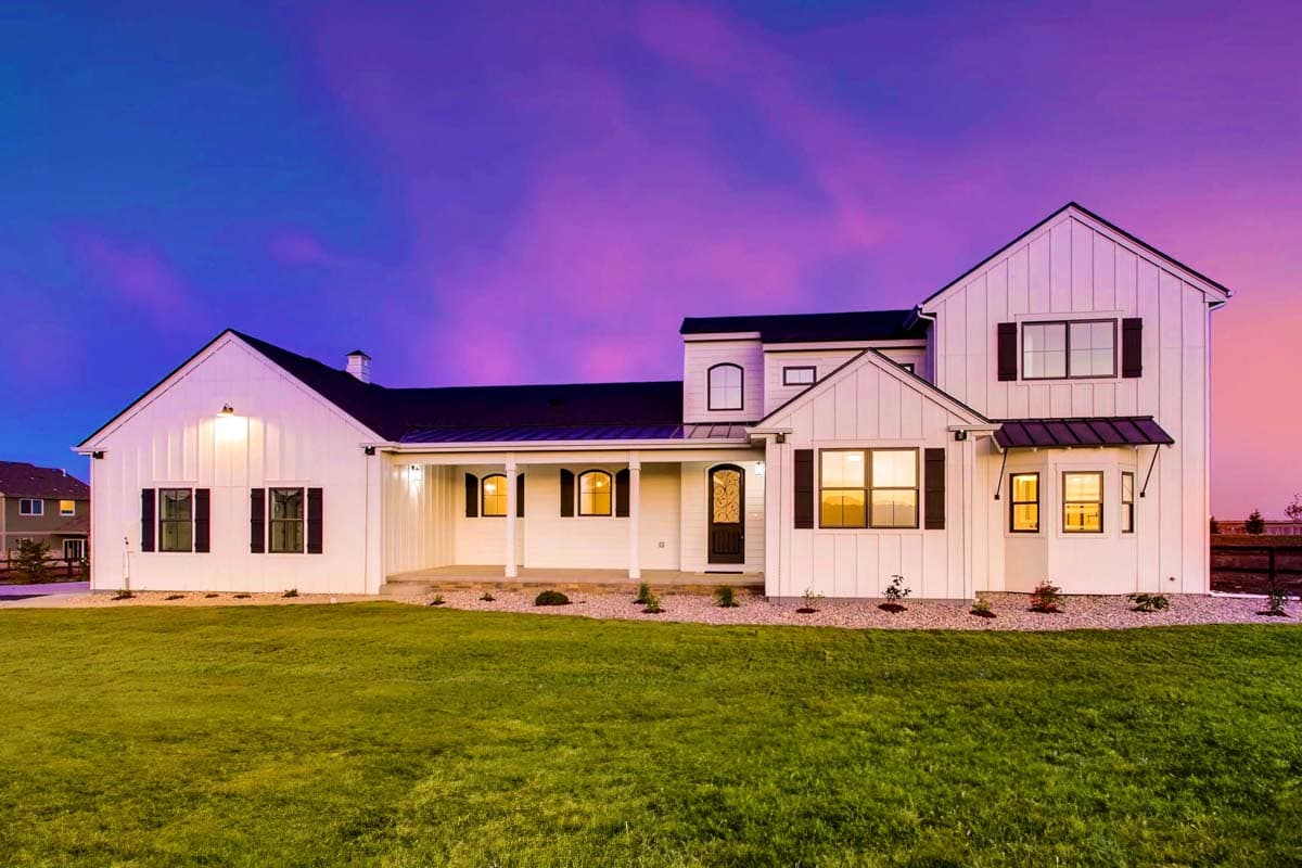 House plan exterior view of a two-story Modern Farmhouse with a gabled roofline, front porch, and black shutters.