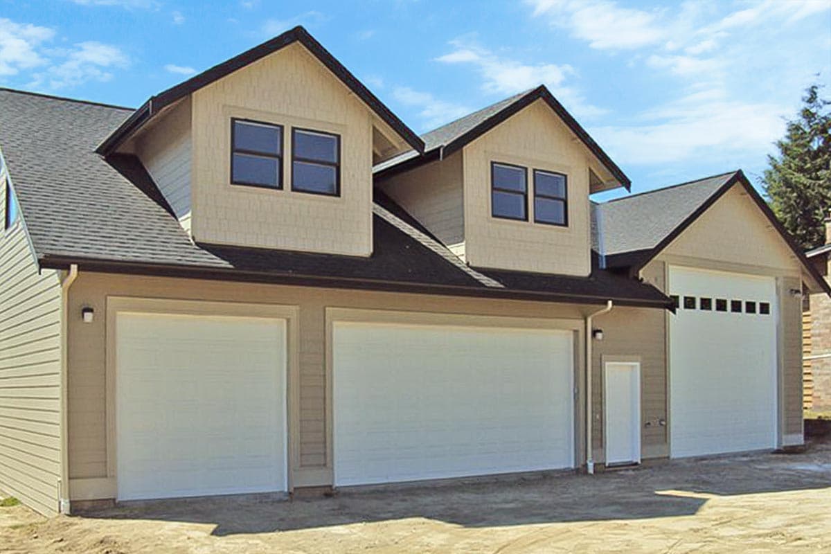 House plan exterior. Two-story home with a gabled roof, two dormers, and a three-car garage. Features include board and batten siding.
