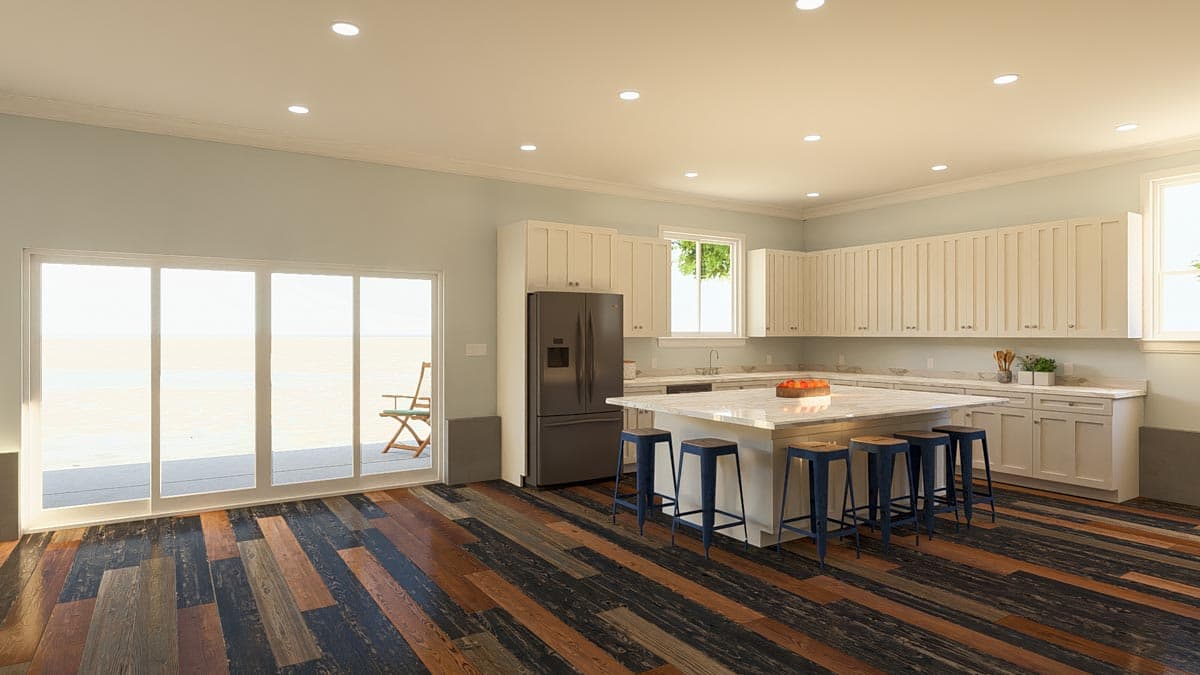 Kitchen with large island, white cabinetry, stainless steel refrigerator, and sliding glass doors leading to an outdoor deck.