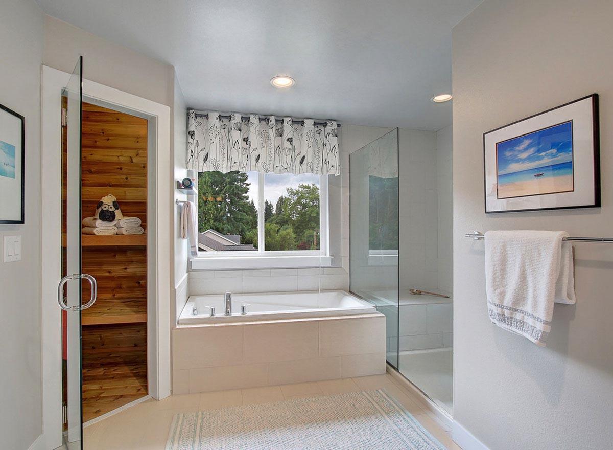 Modern bathroom with built-in soaking tub, glass-enclosed shower, and wood-paneled sauna.