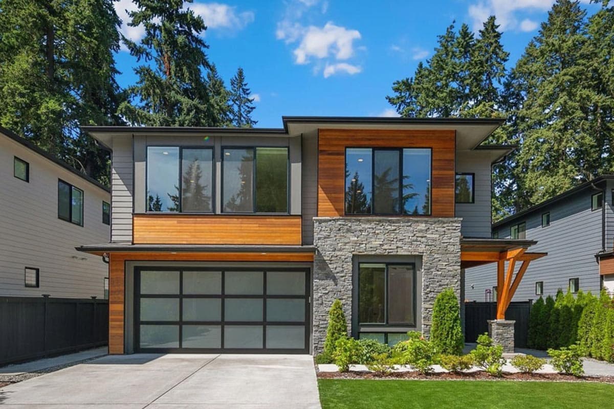 House plan exterior with modern design. Two-story home with a flat roof, stone facade, wood accents, and a glass-paneled garage door.