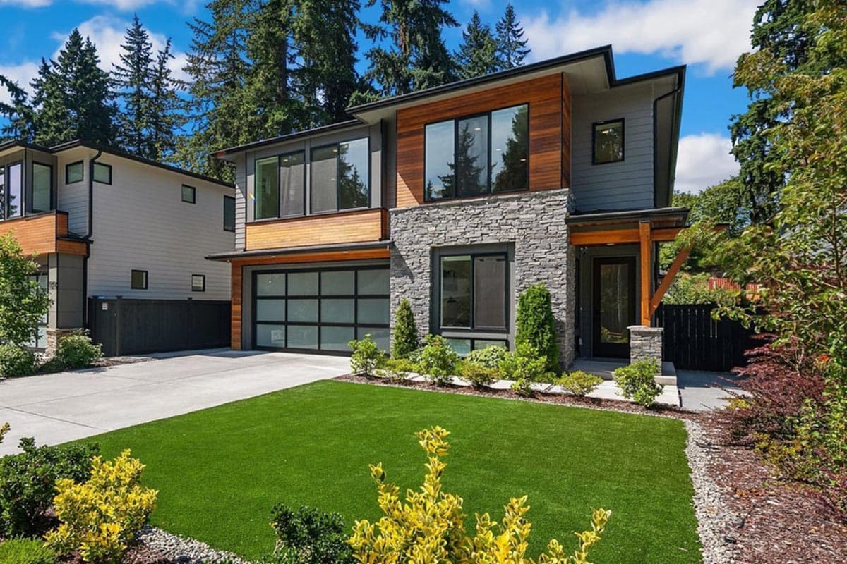Modern house plan exterior with stone and wood facade, flat roof, and glass garage door.