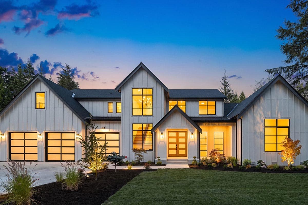 Modern Farmhouse house plan exterior with white board and batten siding, gabled roofs, and glass panel garage doors.