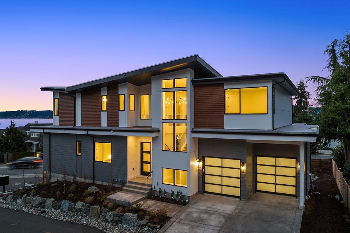 Modern house plan exterior with multiple gables, two-car garage, and large vertical windows.
