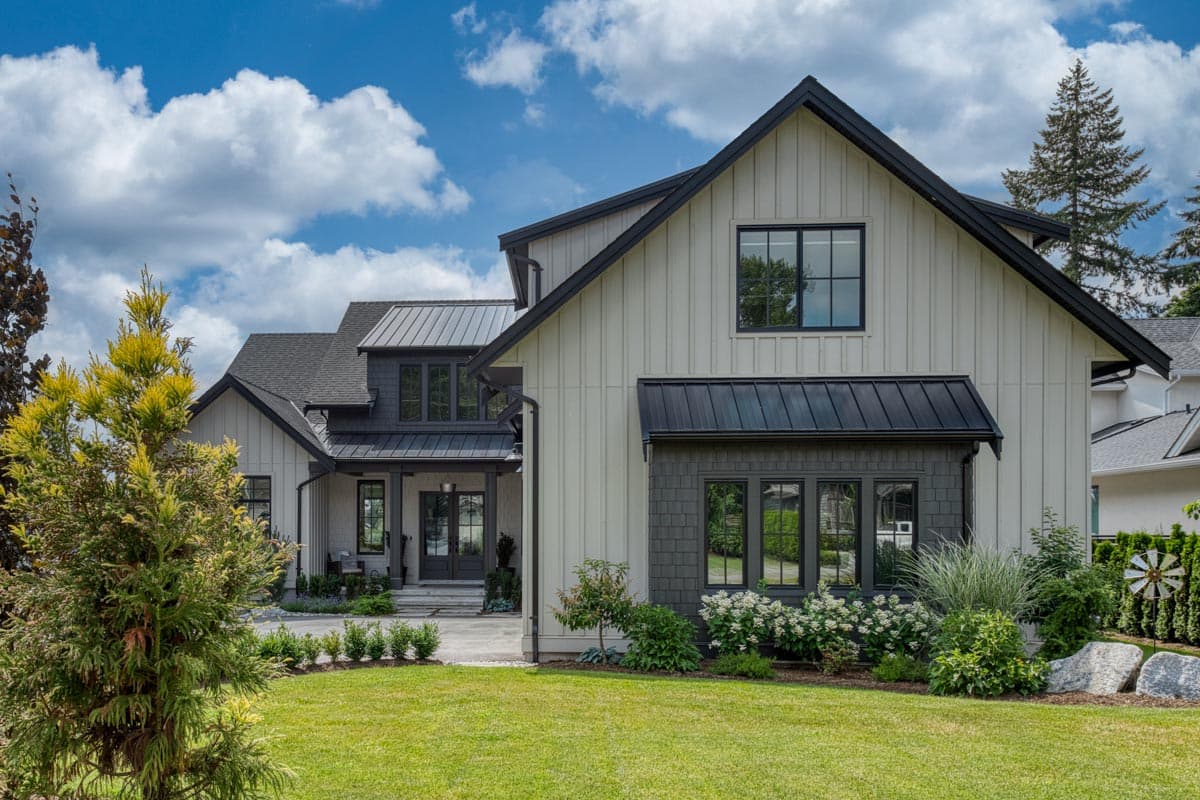 Modern Farmhouse house plan exterior with vertical siding, metal roof, gables, dormers, and a covered entryway.