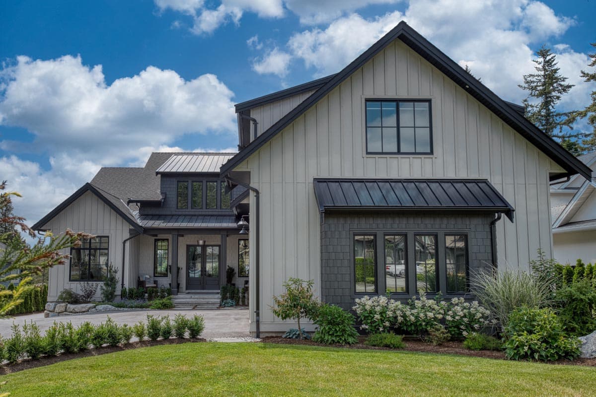 House plan exterior: Modern Farmhouse style, two stories, featuring board and batten siding, metal roof, gables, and covered entry.