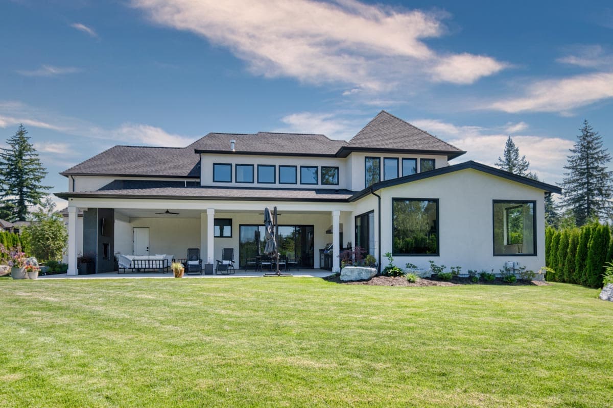 Modern house plan exterior with a covered patio, large windows, and a gabled roofline.