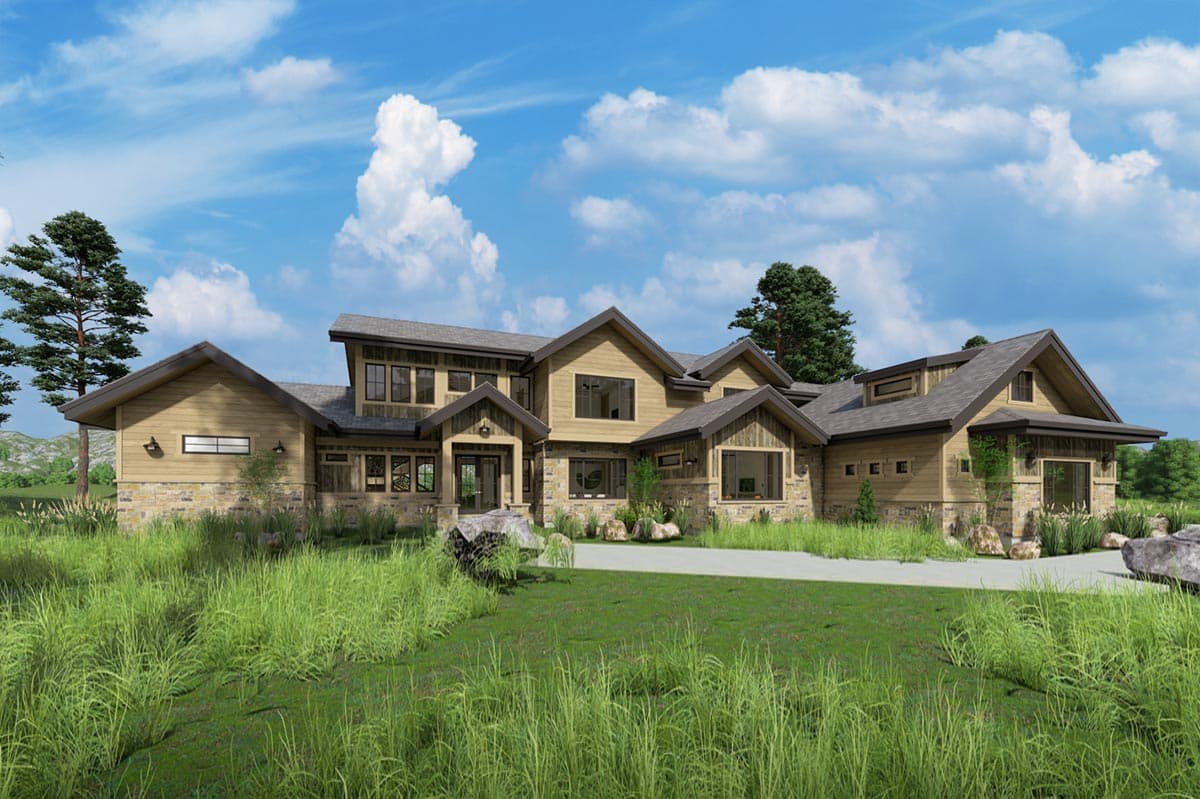 A large, modern home with a stone and wood exterior, set amidst green grass and under a bright blue sky with fluffy clouds.