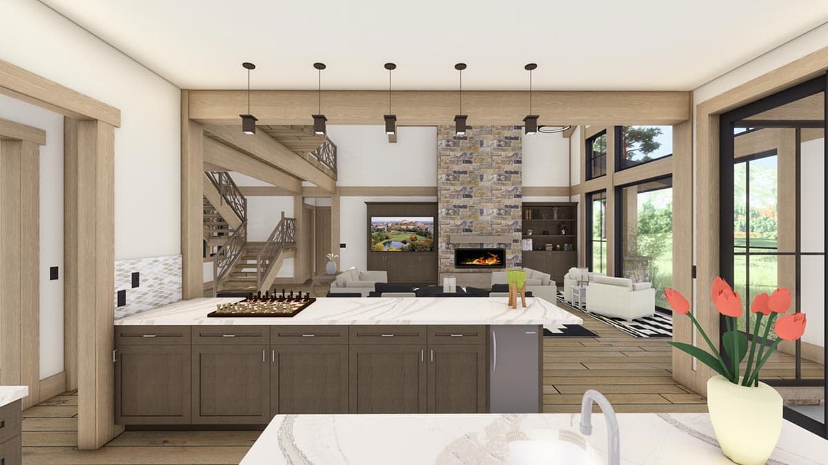 Spacious, modern kitchen and living area with a stone fireplace, overhead lights, and a staircase leading to a loft.