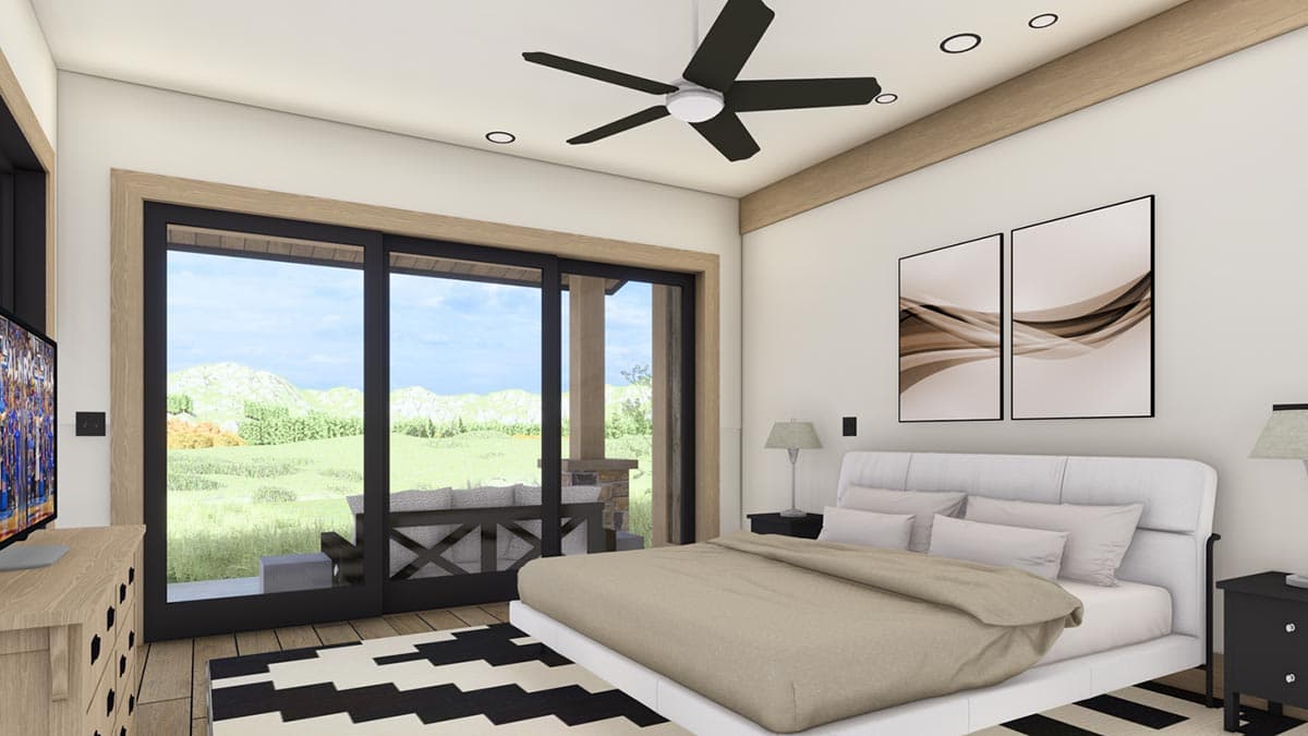 A modern bedroom with a large window overlooking a patio and landscape.  The room has a bed, a ceiling fan, and abstract artwork.