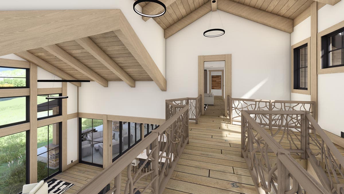 Interior view of a modern wooden home with a mezzanine, featuring decorative railings, and large windows with outdoor views.