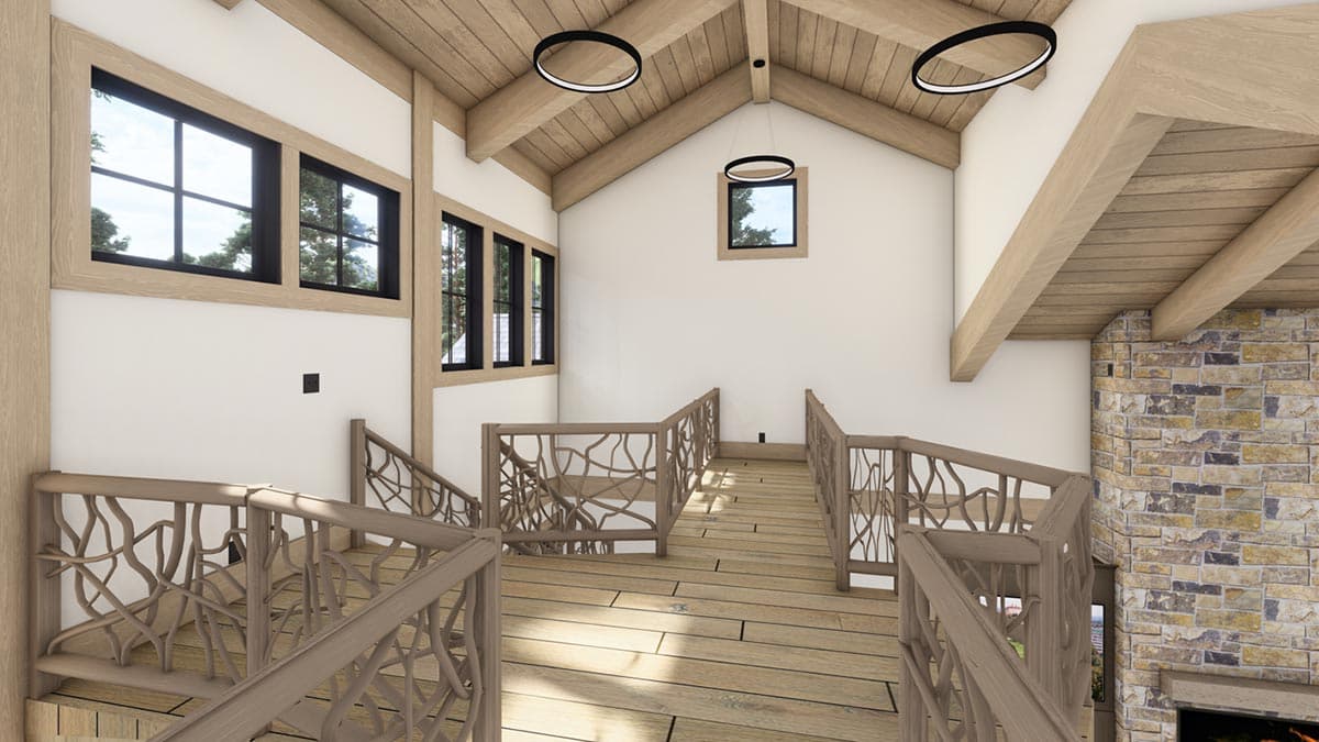 Interior view of a modern cabin. Features wooden floors, intricate railing design, and a stone fireplace. High ceilings with large windows.