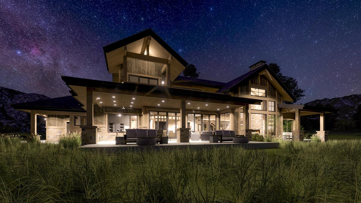 A modern, wooden house illuminated at night under a starry sky. Outdoor seating is visible on a large covered porch overlooking tall grass.
