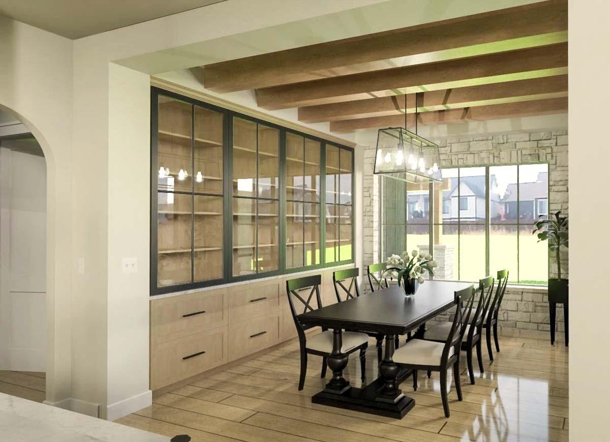 A modern dining room features a dark table and chairs, a large bookcase, and a large window looking out onto a neighborhood.