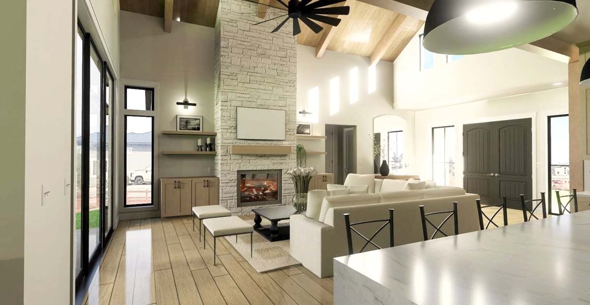 Spacious living room features a stone fireplace, large windows, and a modern, neutral-toned interior with a sectional sofa and hardwood floors.