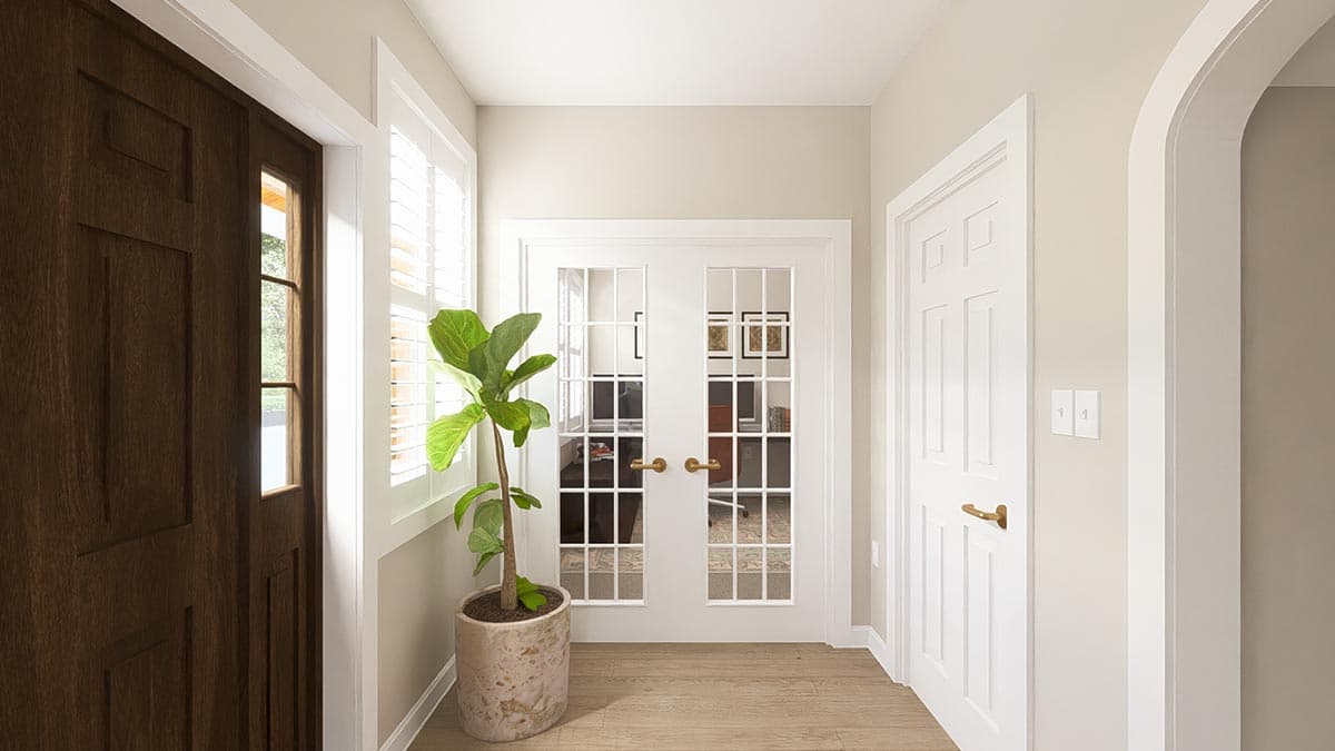 Interior view of a hallway with a dark wood paneled door, white French doors, and a white paneled door, leading to an office.