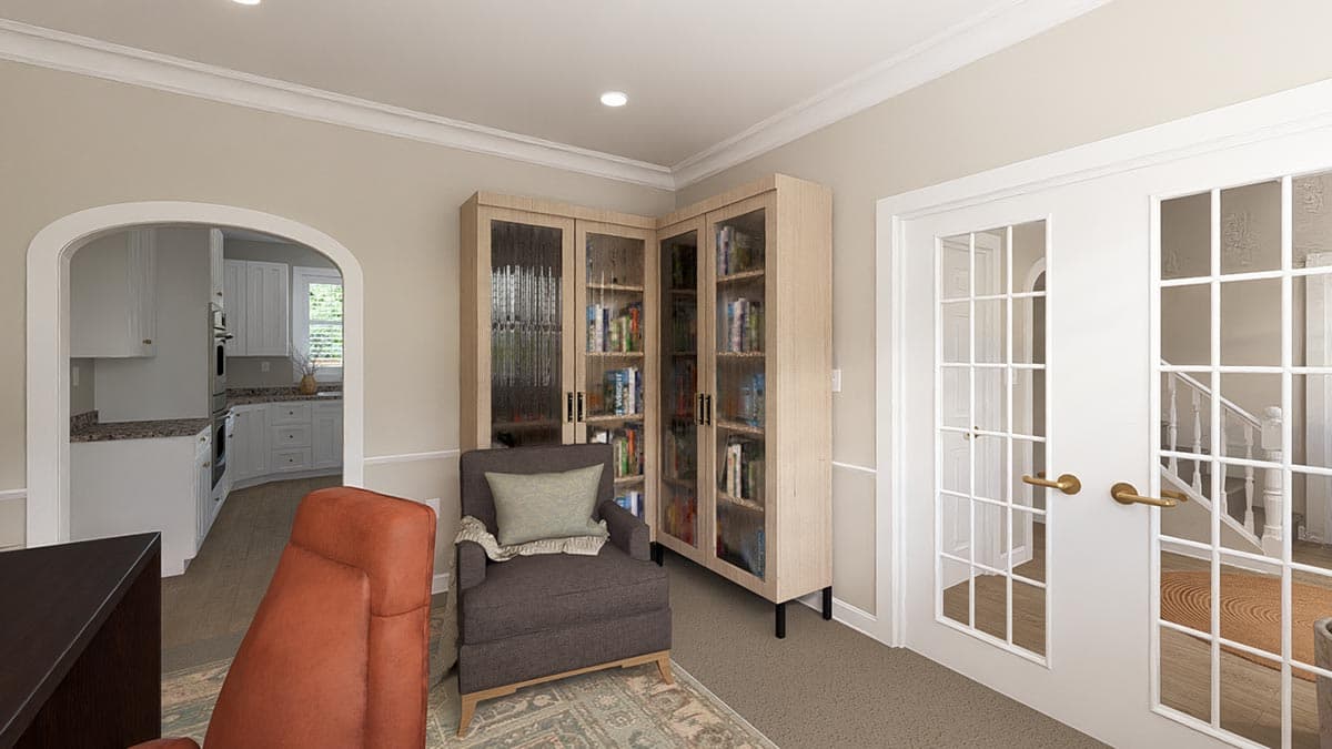 Interior view of a study with a corner bookcase, armchair, and French doors leading to a staircase and kitchen view through an arch.