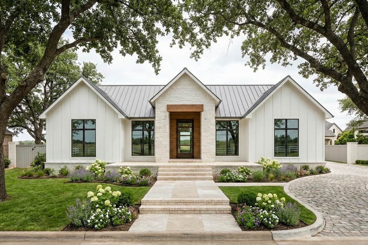 House plan exterior. Modern Farmhouse style with white siding, metal roof, and gabled rooflines. Features include front porch, and large windows.