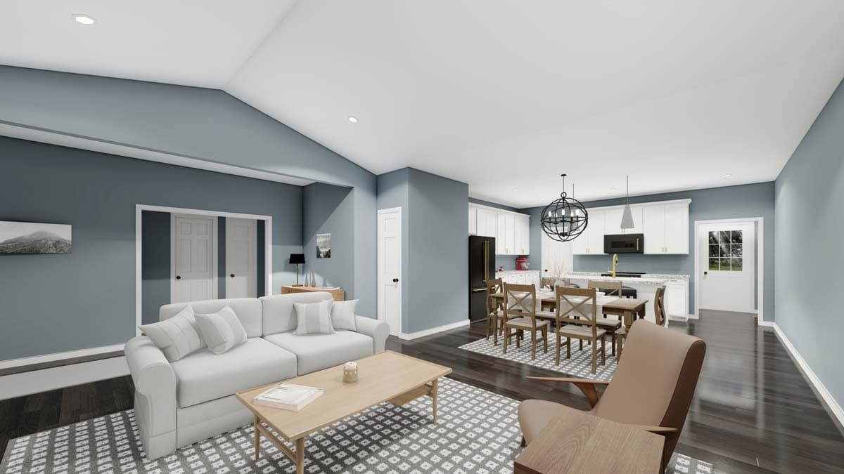 Open concept living area with vaulted ceiling, neutral sofa, dining table, and white kitchen with island.