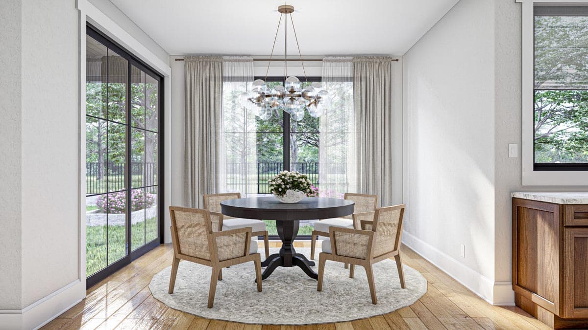 Dining room with round table, four chairs, large windows, and contemporary chandelier.