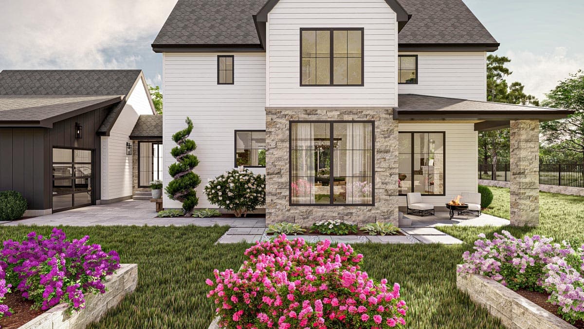 Modern farmhouse exterior with white siding, stone accents, a gable roof, and a covered porch. Features a detached garage with glass doors.
