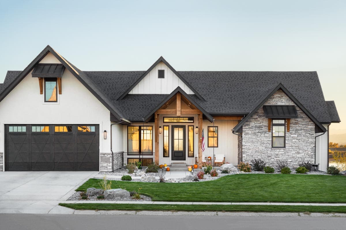 Modern Farmhouse house plan exterior with wood beams, stone accents, dark garage door, and gabled rooflines.