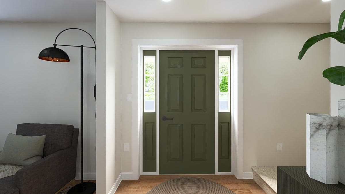 Interior view of a house entrance featuring a dark green paneled door with sidelights, a floor lamp, and part of a sofa.