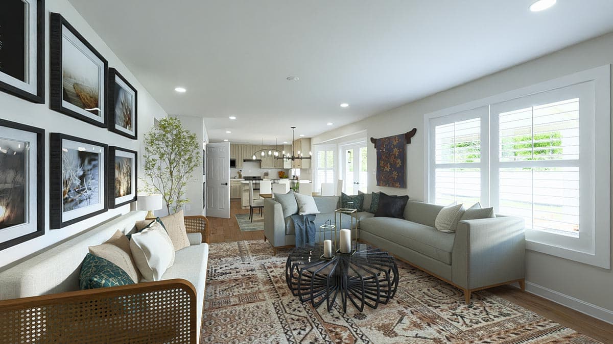 Open-concept living area with sectional sofa, patterned rug, dining area, and kitchen with island. Wall art and large windows are visible.