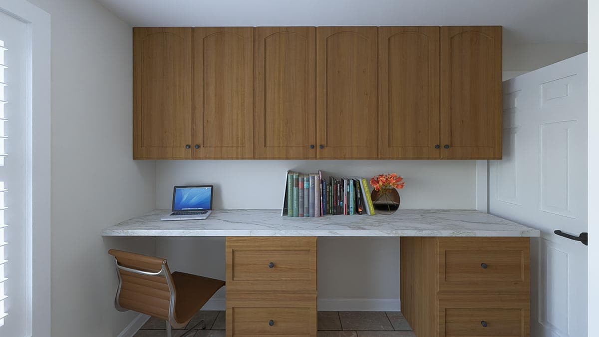 Built-in desk with marble countertop, wooden drawers, and arched upper cabinets. Laptop, books, and vase visible.
