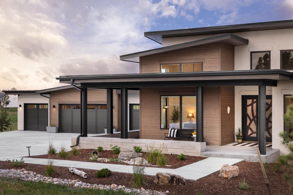 Modern house plan exterior with a covered porch, multiple garages, and wood-paneled walls.