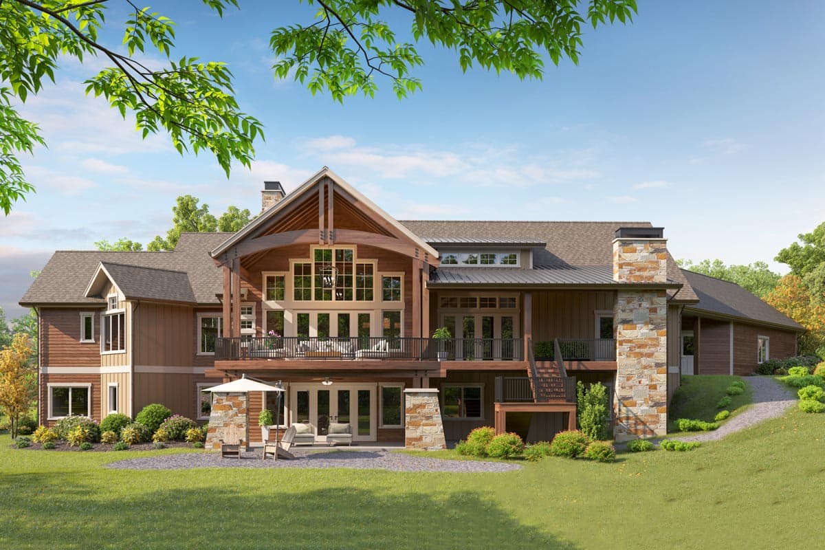 Modern Rustic house plan exterior with wood siding, stone chimney, large windows, covered deck, and walk-out lower level.